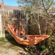 woman laid in an orange hammock reading in the sun with a chihuahua